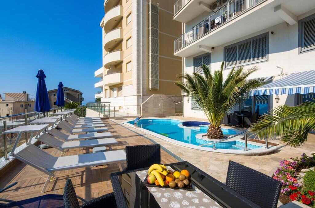 Loungers, palms and the heated outdoor pool